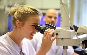 junge Frau am Mikroskop im Labor
